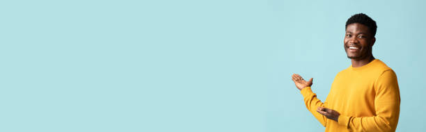 istock Happy black man in casual pointing at copy space 1385723548