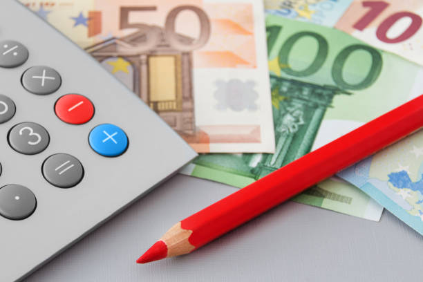 Finances and Euro banknotes with calculator and red pencil
