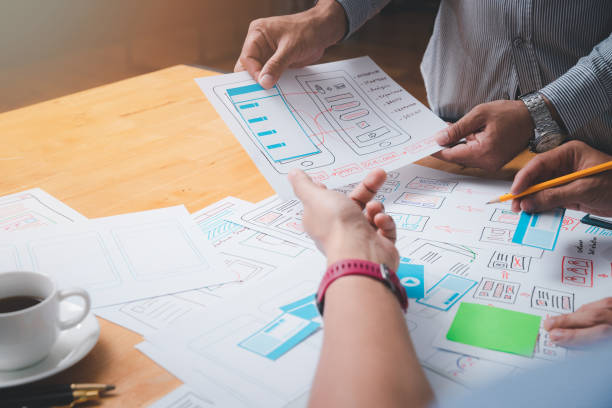 istock UX or UI designers designing on their smartphone application layout prototype project. 1385725325