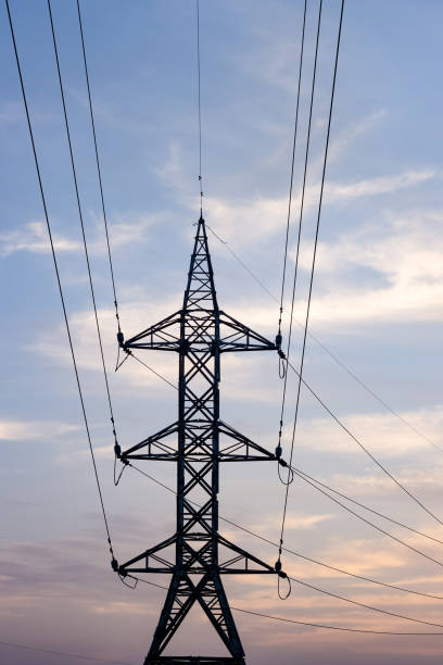 istock Electricity transmission tower front view under the evening cloudy sky 1385726107