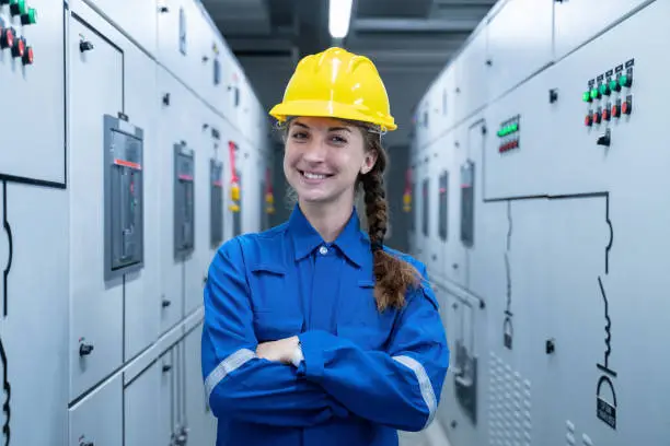 Woman Electrical Engineer working front HVAC control panels, Technician daily check solar cell controls system for security functions in service room at factory.Energy,Ventilation,Air Conditioning.