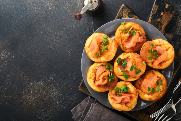 istock Yorkshire pudding. Traditional English Yorkshire pudding with salmon and radish microgreens side dish on dark grey plate and dark background table. Top view. 1385729109