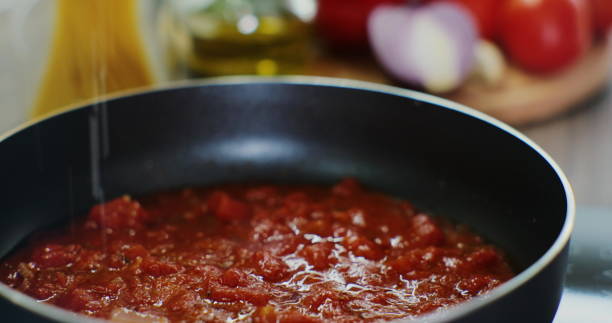 istock Process of preparing a tomato sauce in a hot pan, close-up. Fresh vegetables background. 1385729312