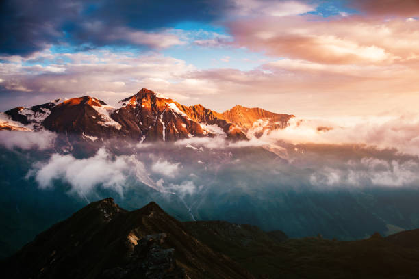 A look at the sunlit hills at twilight. Dramatic evening scene. Location place Grossglockner High Alpine Road, Austria. Europe. Climate change. Popular tourist attraction. Explore the world's beauty.