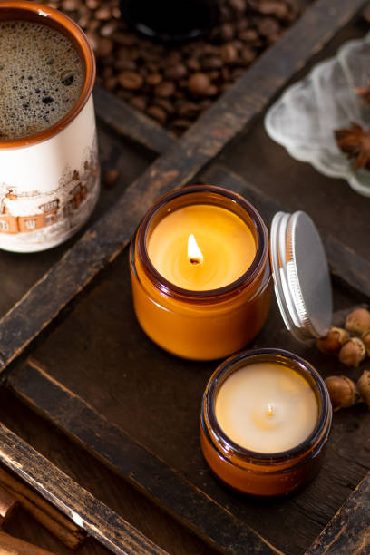 un conjunto de velas de diferente aroma en frascos de vidrio sobre un fondo blanco. vela perfumada hecha a mano. las velas de soja se queman en un frasco. cera y parafina en un frasco - paraffin fotografías e imágenes de stock