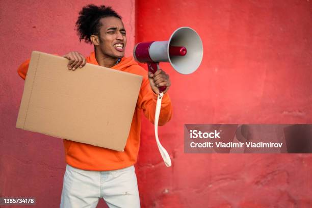A Male Protestor Using A Megaphone And Holding A Blank Placard Stock Photo - Download Image Now