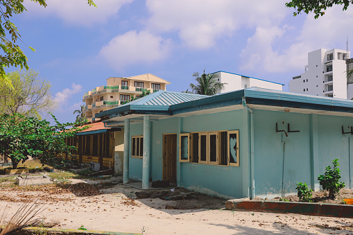 Ruins of the Wooden Houses with the Maldivian Hotel Building on the Background, Maafushi Island