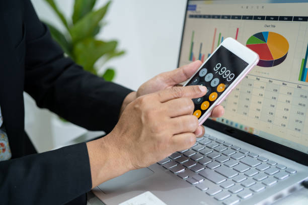 istock Asian accountant working and analyzing financial reports project accounting with chart graph and calculator in modern office, finance and business concept. 1385736511