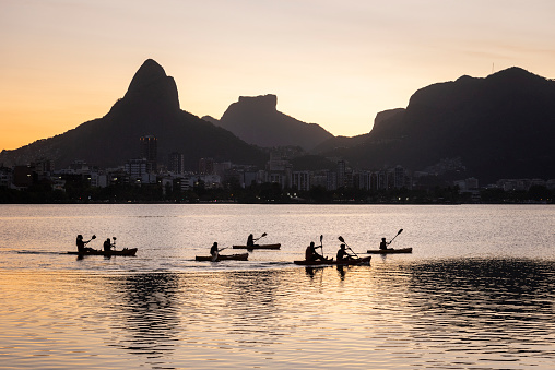 Beautiful view to people kayaking on city lake with mountains in Rio de Janeiro, State of Rio de Janeiro, Brazil