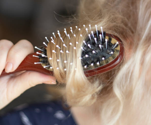 istock selective focus. blond combing wet and tangled hair. 1385737986