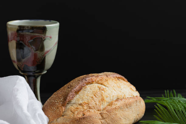 Chalice, bread, palm leaves and white linen stock photo