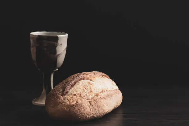 Photo of Chalice and bread on black