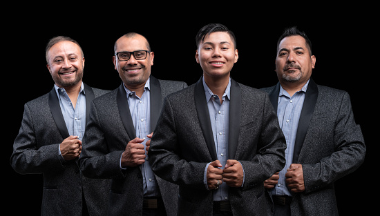 Portrait of Smiling four hispanic men looking at the camera on black background