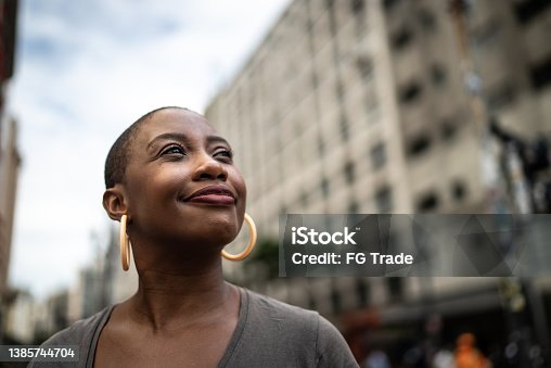 istock Contemplative mid adult woman in the street 1385744704