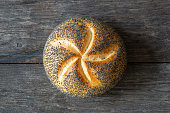 single round bread roll with poppy seeds, close up, top view