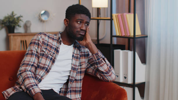 istock African american man at home suffers from unfair situation problem, break up, depressed, feeling bad 1385748080