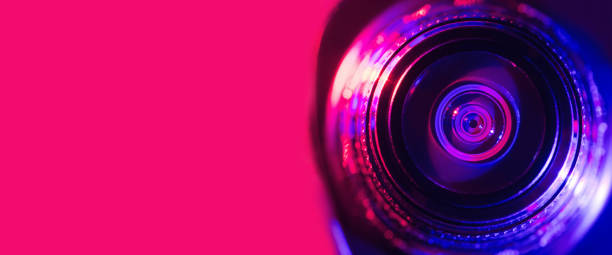 istock Camera lens with purple and pink backlight. Cyberpunk style. Banner 1385748174
