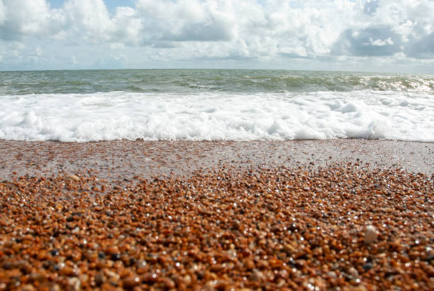 Waves washing over red shingle gravel Ventnor beach, Isle of wight in the United Kingdom