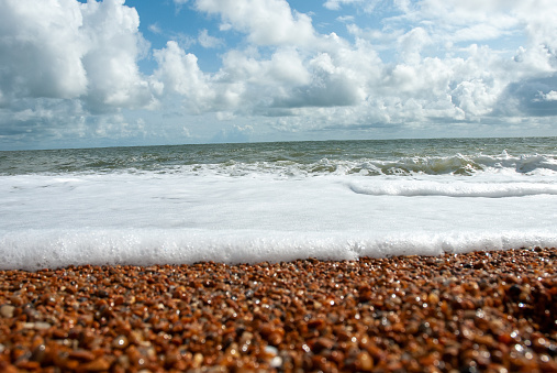 Waves washing over red shingle gravel Ventnor beach, Isle of wight in the United Kingdom