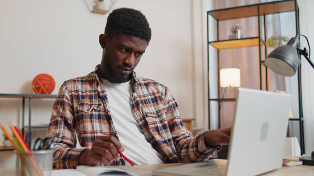 istock Young man guy using laptop computer sitting at table working, online shopping from home office 1385748689