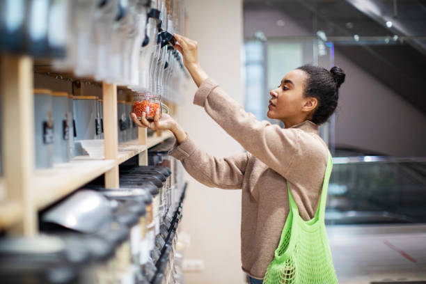 Mujer comprando comida en una tienda de cero residuos - foto de stock