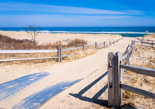 A blue mat, partially covered by sand from winter winds, offers handicapped access to Coast Guard Beach in the Cape Cod National Seashore, known as one of the best beaches in the United States.