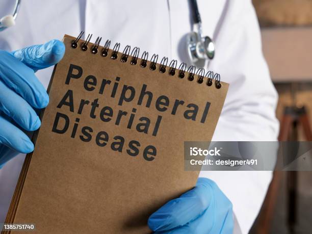 Doctor Shows Page With Peripheral Arterial Disease Pad Stock Photo - Download Image Now