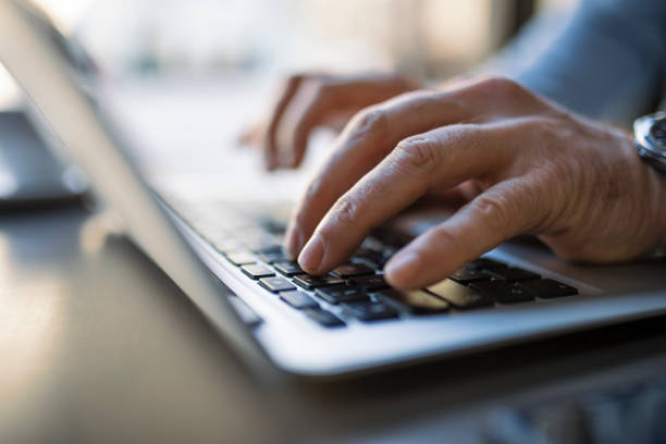 istock Unrecognizable businessman sitting at coffee shop using laptop 1385754770