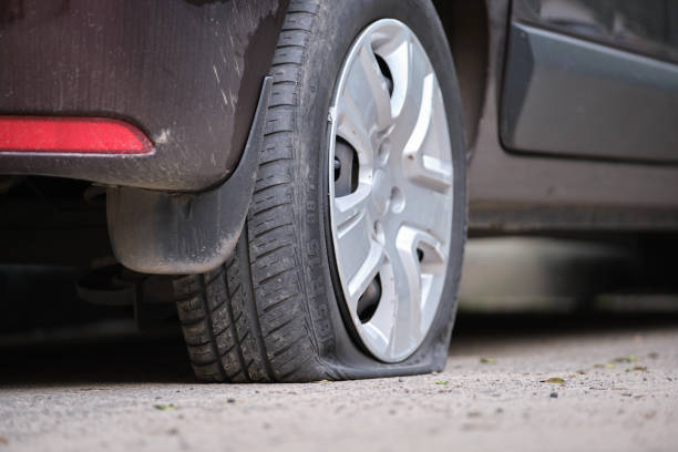 istock Car with punctured flat tire parked on roadside 1385755372