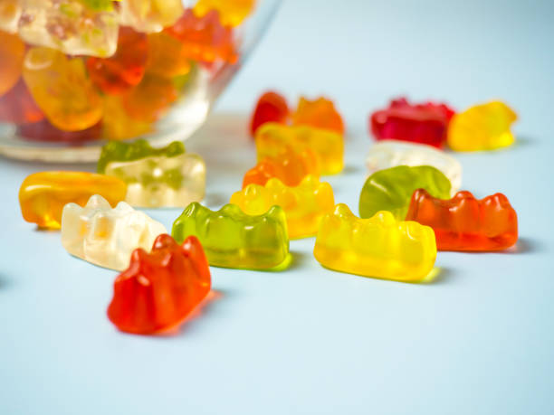 istock Bowl with tasty bright gummy bears on blue table 1385761577