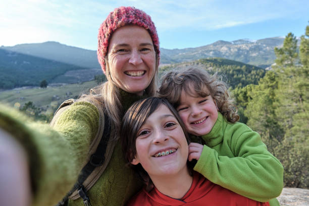 A happy mother and sons making selfie with background mountain stock photo