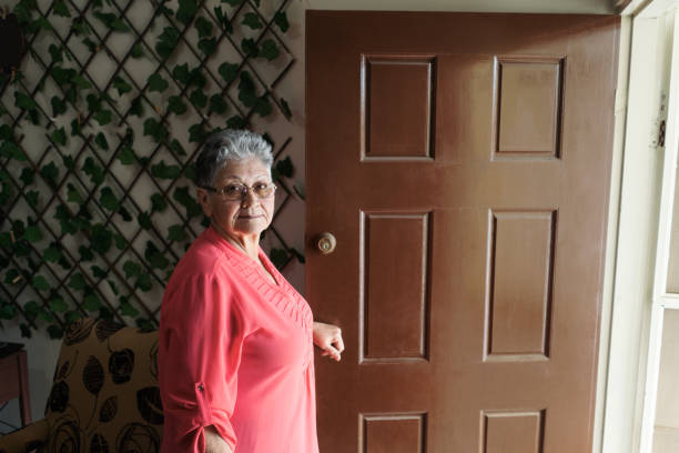 istock Senior woman standing on her doorway 1385761817