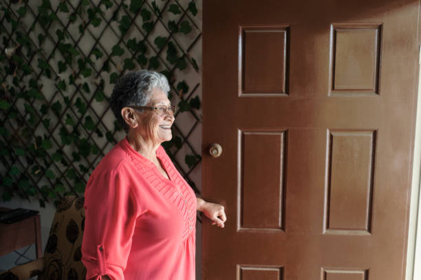 istock Smiling senior woman standing on her doorway 1385761821