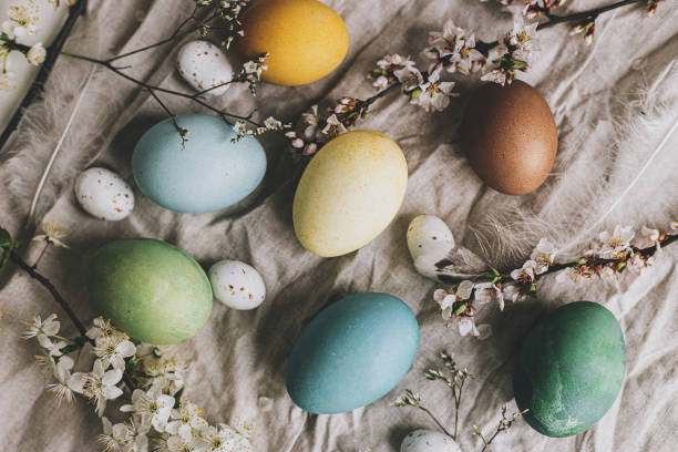 istock Stylish Easter eggs and cherry blossoms on rustic linen cloth flat lay. Happy Easter! Natural dyed colorful pastel eggs and spring flowers rustic composition. Greeting card 1385763423