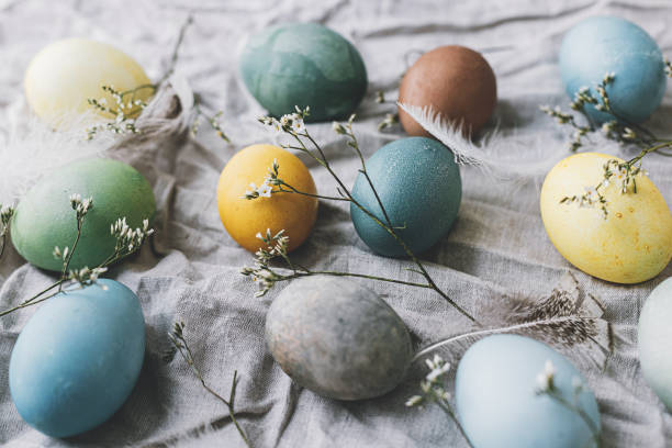 istock Happy Easter! Easter eggs on rustic linen napkin with tender flowers. Stylish natural dyed pastel colorful egg, spring flowers and feathers composition. Rustic still life 1385765358