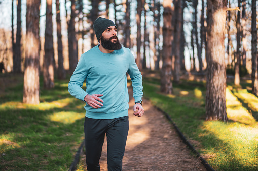 Man with beard   enjoys  jogging in nature.