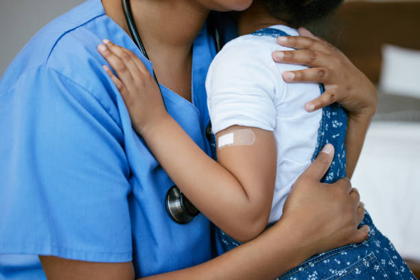 снимок медсестры, обнимающей маленькую девочку с гипсом на руке - close to стоковые фото и изображения