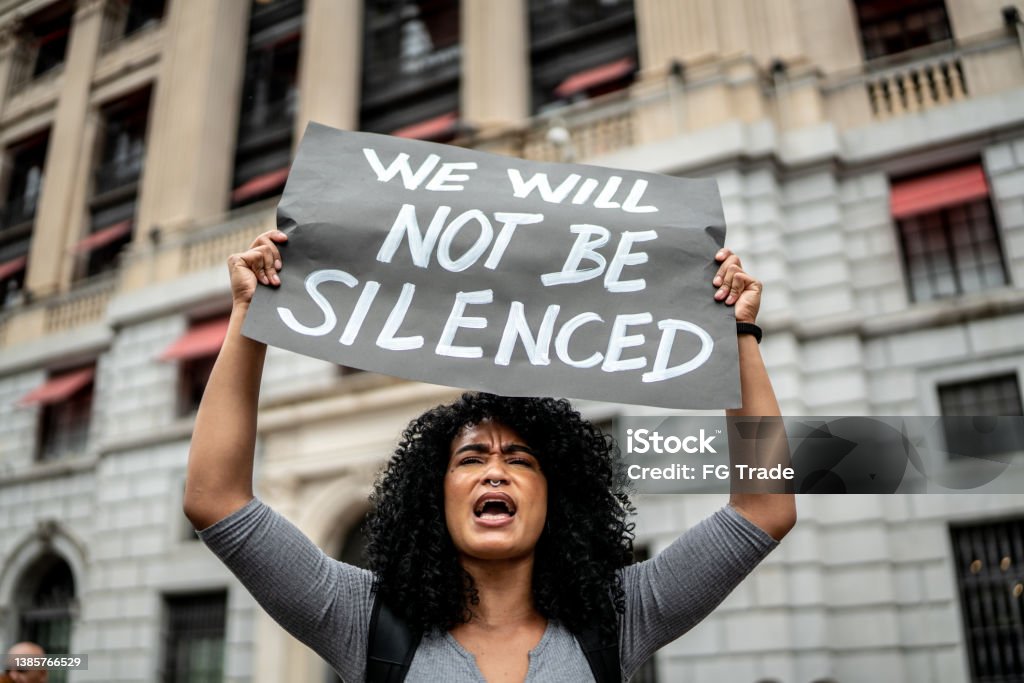 Woman holding signs during on a demonstration outdoors Protest Stock Photo