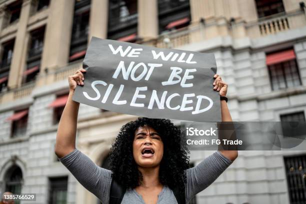 Woman Holding Signs During On A Demonstration Outdoors Stock Photo - Download Image Now