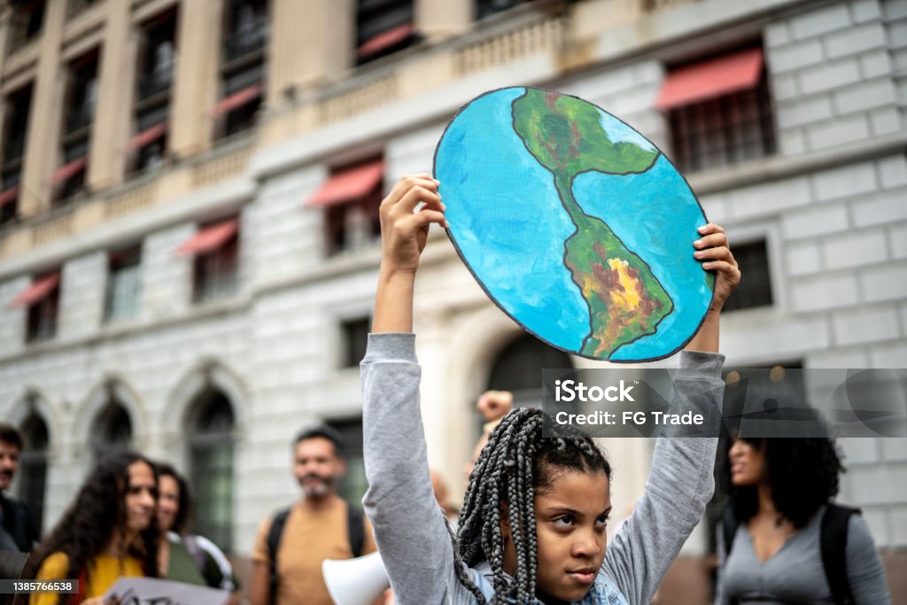 Teenager girl holding signs during on a demonstration for environmentalism Climate Change Stock Photo