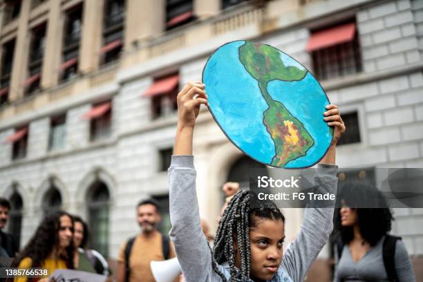 Teenager Girl Holding Signs During On A Demonstration For Environmentalism Stock Photo - Download Image Now