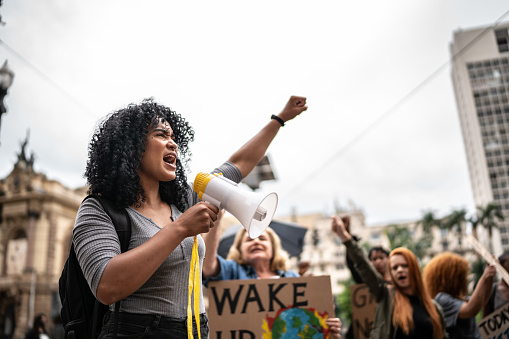 Young woman leading a demonstration using a megaphone