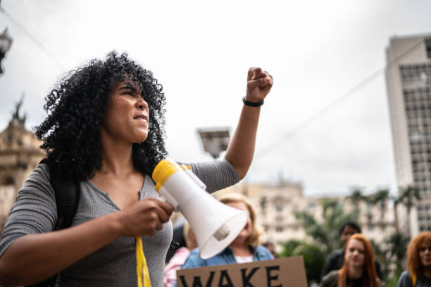 istock Young woman leading a demonstration using a megaphone 1385767439