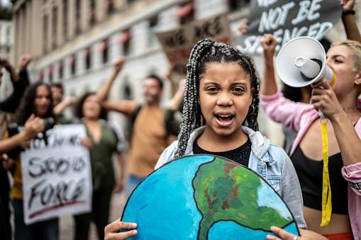 Retrato de una adolescente sosteniendo carteles durante una manifestación por el ecologismo photo