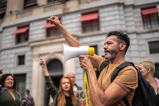 Hombre maduro liderando una demostración usando un megáfono photo