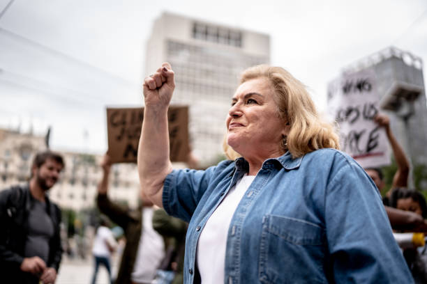 抗議運動を率いる上級女性 - protest women marching street ストックフォトと画像