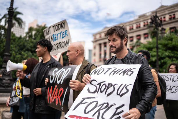 istock Protesters holding signs during a demonstration in the street 1385768021