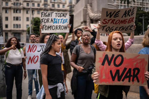 istock Protesters holding signs during a demonstration in the street 1385768032