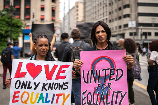 Mujeres transgénero sosteniendo carteles durante una manifestación en la calle photo