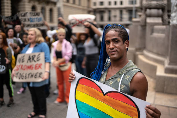 Transgender woman holding a sign during a demonstration in the street Transgender woman holding a sign during a demonstration in the street LGBT stock pictures, royalty-free photos & images
